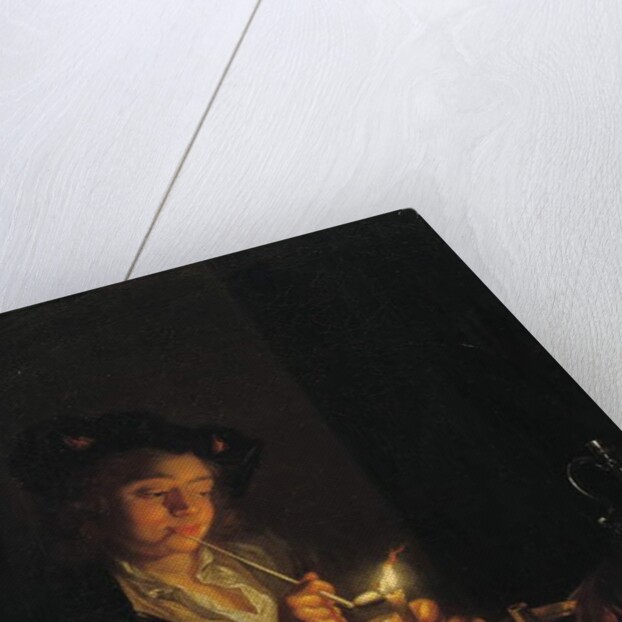 A candlelit interior with a young man seated at a table, lighting his pipe by Arnold Boonen