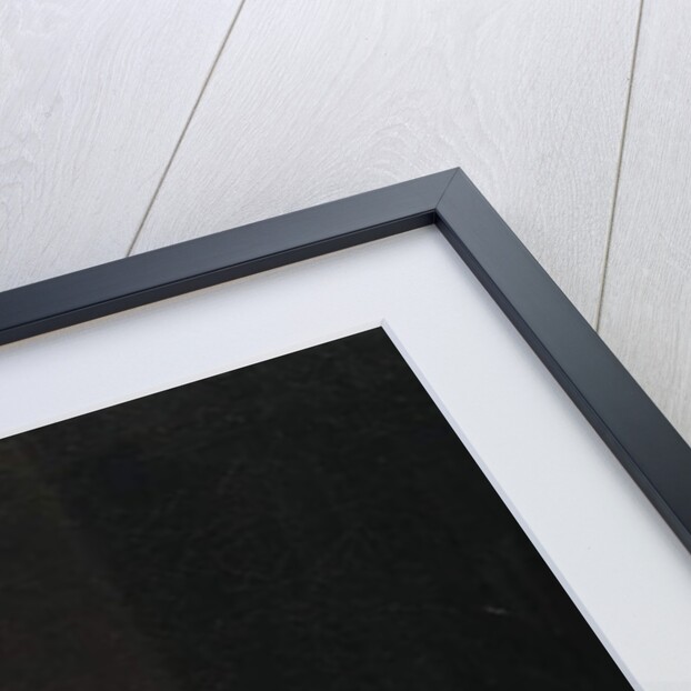 A candlelit interior with a young man seated at a table, lighting his pipe by Arnold Boonen