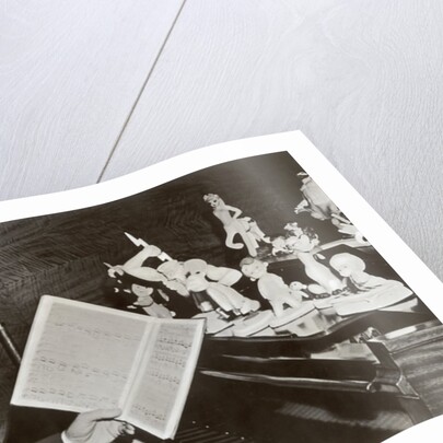 Walt Disney plays piano to a group of figures of Disney characters, c.1940 by German Photographer