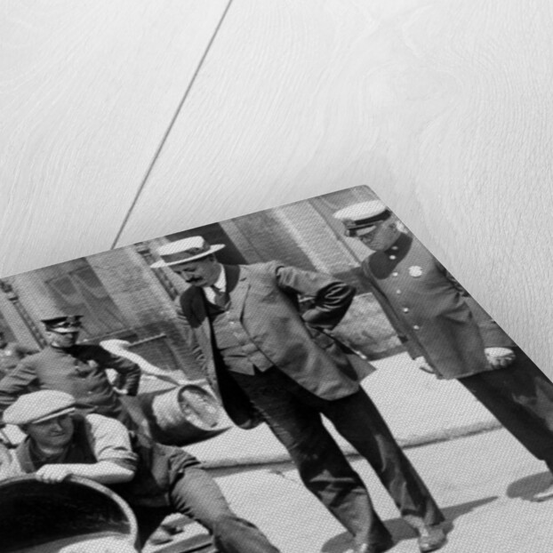 New York City Deputy Police Commissioner John A. Leach, watching agents pour liquor into sewer following a raid during the height of prohibition, c.1921 by American Photographer