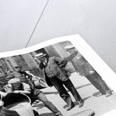 New York City Deputy Police Commissioner John A. Leach, watching agents pour liquor into sewer following a raid during the height of prohibition, c.1921 by American Photographer