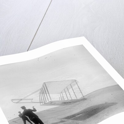 Wilbur Wright at left and Orville Wright at right, with a glider flying as a kite near the ground, 1901 by Anonymous