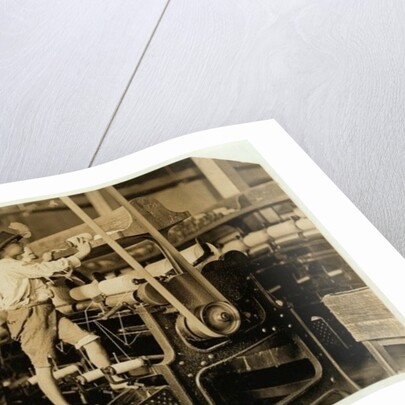 Small boys climbing on spinning frame to mend broken threads and replace empty bobbins at Bibb Mill, Macon, Georgia, 1909 by Lewis Wickes Hine