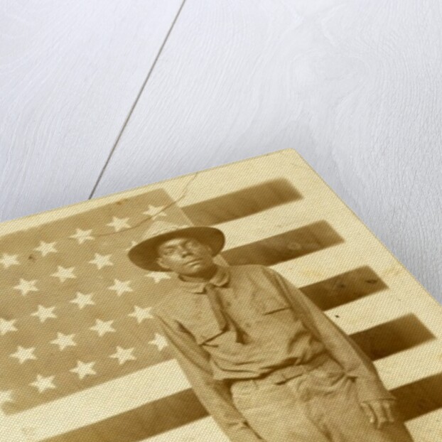 World War I soldier with American flag in background, 1914-18 by American Photographer