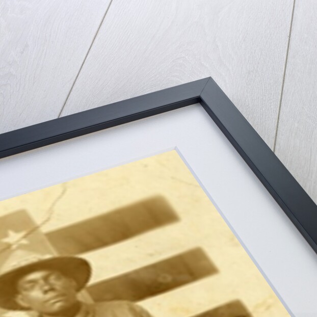 World War I soldier with American flag in background, 1914-18 by American Photographer