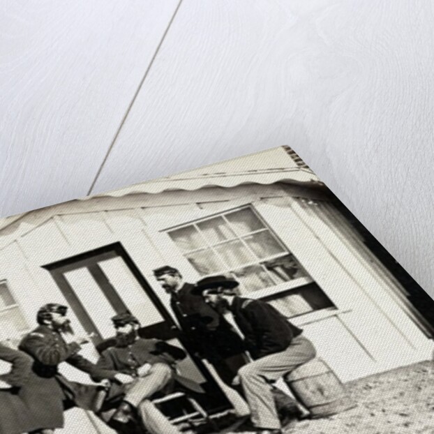 Five Civil War soldiers gathered on dirt porch outside home, African American youth seated near them, 1861-65 by American Photographer