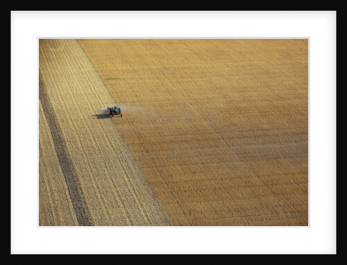 A tractor harvesting by Anonymous