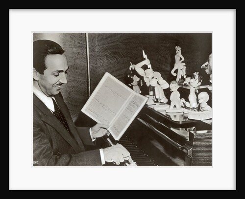 Walt Disney plays piano to a group of figures of Disney characters, c.1940 by German Photographer