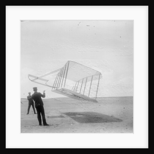 Wilbur Wright at left and Orville Wright at right, with a glider flying as a kite near the ground, 1901 by Anonymous