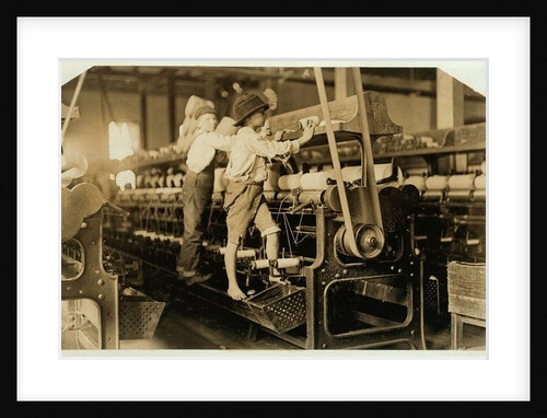 Small boys climbing on spinning frame to mend broken threads and replace empty bobbins at Bibb Mill, Macon, Georgia, 1909 by Lewis Wickes Hine