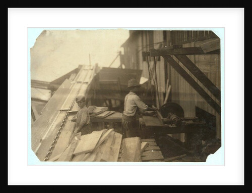 Charlie McBride aged 12 takes wood from a chute for 10 hours at Miller & Vidor Lumber Company, Beaumont, Texas by Lewis Wickes Hine