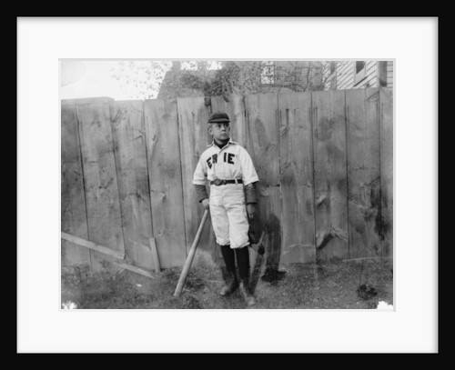 Boy in baseball uniform by fence by Anonymous