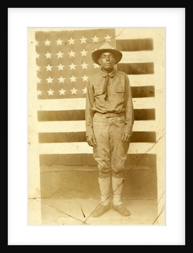 World War I soldier with American flag in background, 1914-18 by American Photographer