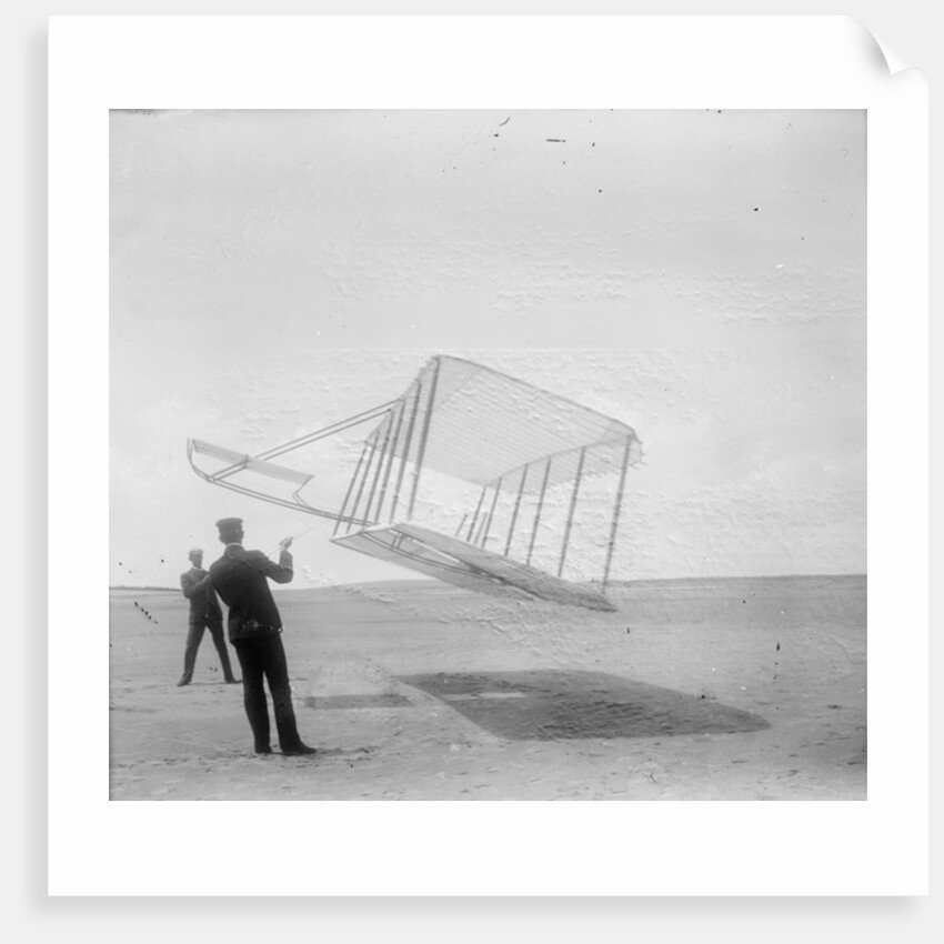 Wilbur Wright at left and Orville Wright at right, with a glider flying as a kite near the ground, 1901 by Anonymous