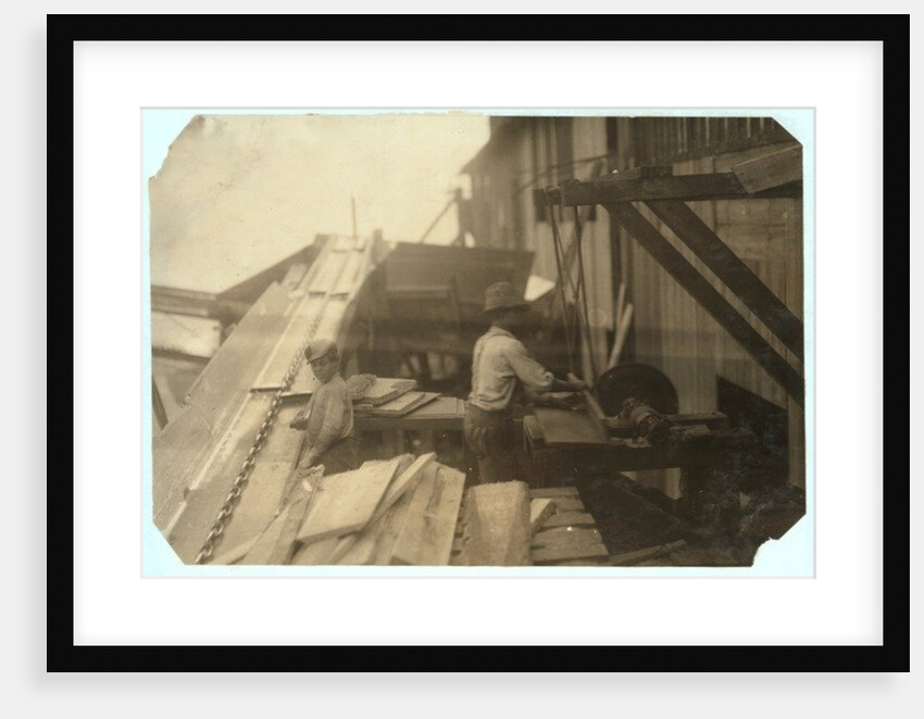 Charlie McBride aged 12 takes wood from a chute for 10 hours at Miller & Vidor Lumber Company, Beaumont, Texas by Lewis Wickes Hine