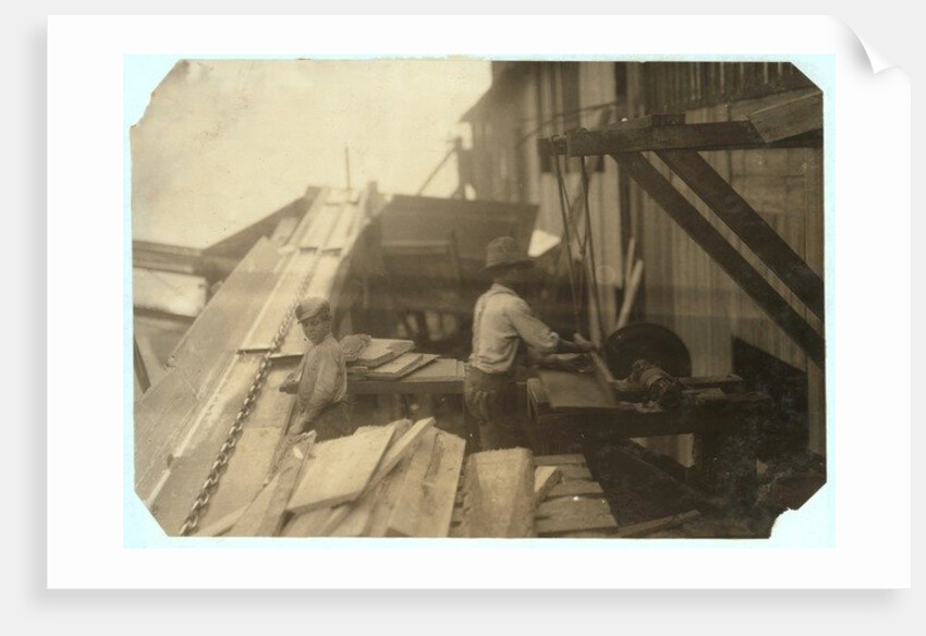 Charlie McBride aged 12 takes wood from a chute for 10 hours at Miller & Vidor Lumber Company, Beaumont, Texas by Lewis Wickes Hine