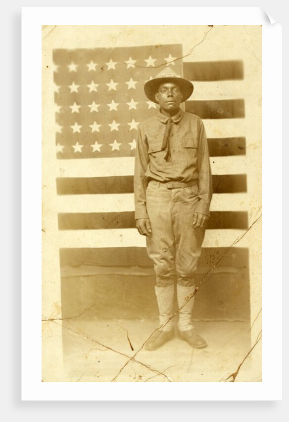 World War I soldier with American flag in background, 1914-18 by American Photographer