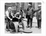 New York City Deputy Police Commissioner John A. Leach, watching agents pour liquor into sewer following a raid during the height of prohibition, c.1921 by American Photographer