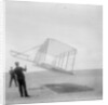 Wilbur Wright at left and Orville Wright at right, with a glider flying as a kite near the ground, 1901 by Anonymous