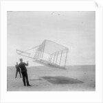 Wilbur Wright at left and Orville Wright at right, with a glider flying as a kite near the ground, 1901 by Anonymous