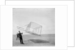 Wilbur Wright at left and Orville Wright at right, with a glider flying as a kite near the ground, 1901 by Anonymous