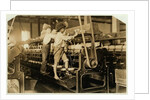 Small boys climbing on spinning frame to mend broken threads and replace empty bobbins at Bibb Mill, Macon, Georgia, 1909 by Lewis Wickes Hine