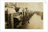 Boy sweeper by carding machines at Lincoln Cotton Mills, Evansville, Indiana in stockinged feet on a slippery floor, 1908 by Lewis Wickes Hine