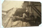 Charlie McBride aged 12 takes wood from a chute for 10 hours at Miller & Vidor Lumber Company, Beaumont, Texas by Lewis Wickes Hine