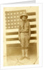 World War I soldier with American flag in background, 1914-18 by American Photographer