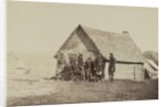 A group of soldiers, and two young men, one an African American, stand outside of log cabin quarters by American Photographer