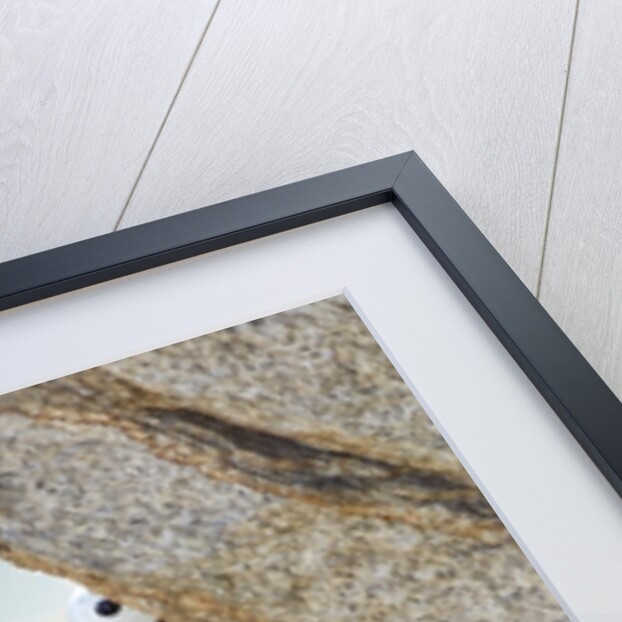Young man rock climbing up a vertical cliff by Anonymous