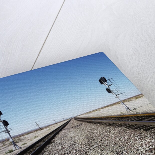 Railroad tracks running through desert setting by Anonymous