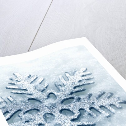 Snowflake Shaped Christmas Ornament Lying in the Snow by Anonymous