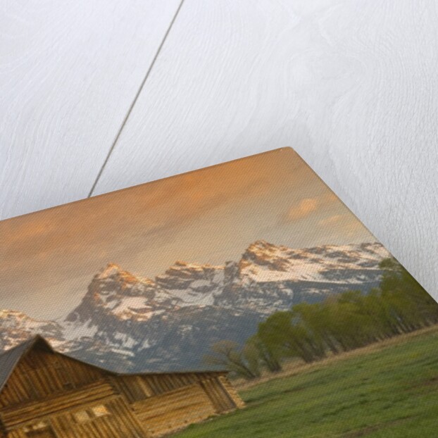 Log Barn in Meadow near Mountain Range by Anonymous