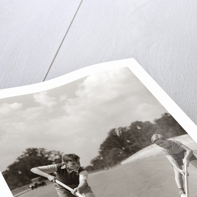 1930s 1940s 2 Boys With Sticks And Puck Wearing Roller Skates Playing Street Hockey by Anonymous