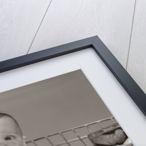 1960s Baby Sitting In Supermarket Cart Full Of Cans Eating Candy Bar With A Messy Face by Anonymous