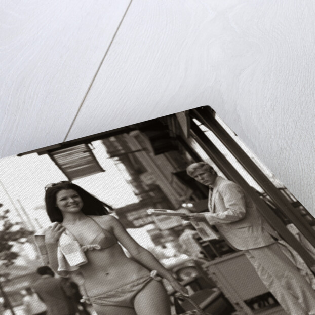 1970s Man Ogling Sexy Young Woman Walking Down City Street Wearing Only A Bikini by Anonymous