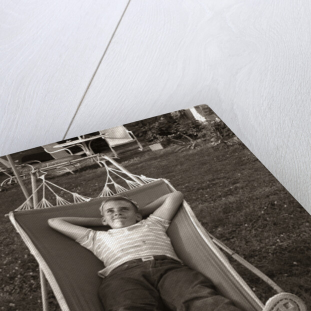 1950s Relaxed Boy Lying In Suburban Backyard Hammock by Anonymous