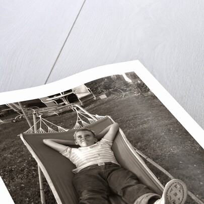 1950s Relaxed Boy Lying In Suburban Backyard Hammock by Anonymous