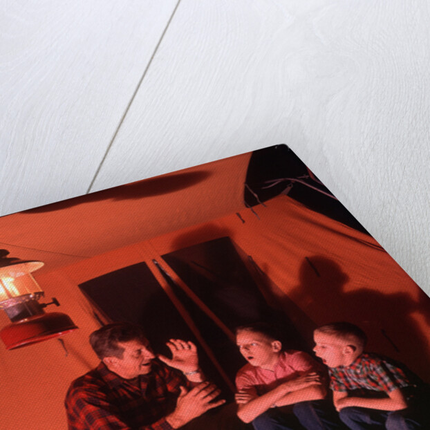1960s 1970s Grandfather Telling Scary Story To Boys By Tent At Night Campsite In Shadows by Anonymous