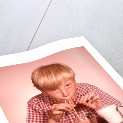 1950s 1960s Boy Drinking Three Milkshakes Through A Straw At Same Time by Anonymous