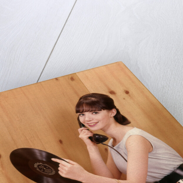 1950s Teenage Girl Talking On Telephone And Holding LP Record by Anonymous