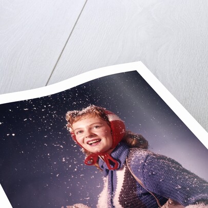 1960s Young Woman Wearing Red Mittens Ear Muffs Blue Sweater Holding Ice Skates In Falling Snow by Anonymous