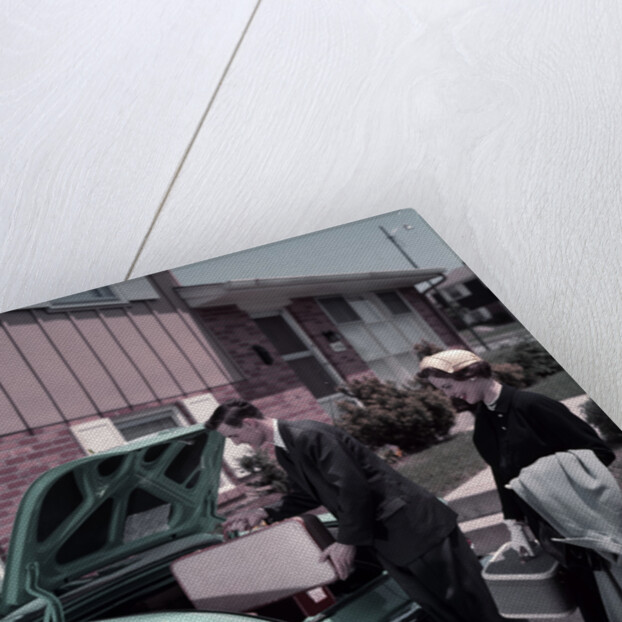 1950s Family Mother Father Daughter In Front Of Suburban House Packing Luggage In Car For Vacation by Anonymous