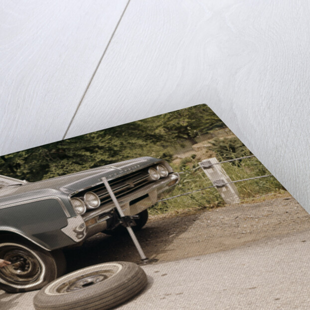1960s Man Changing Flat Tire On Car At Side Of Rural Road Car Jack Tools Tire Iron by Anonymous