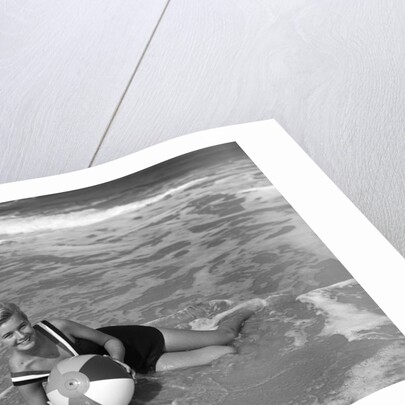 1960s Woman In Bathing Suit Lying In The Surf Holding A Beach Ball Outdoor by Anonymous