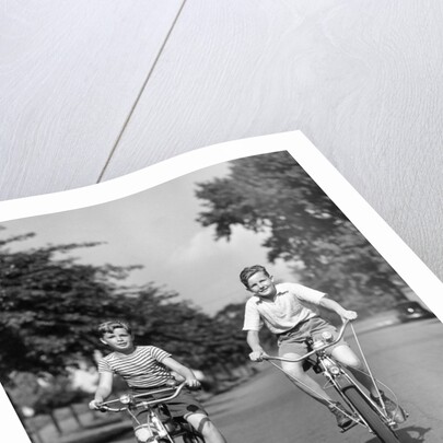 1930s 1940s Two Boys Riding Bikes On Tree Lined Street by Anonymous