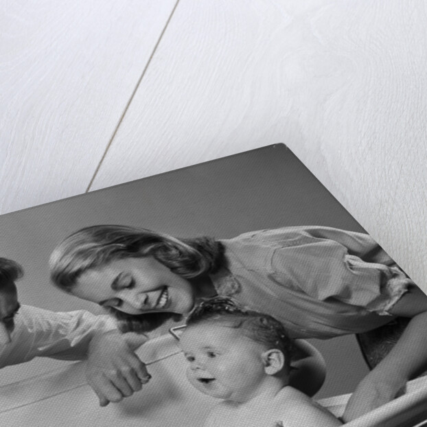 1950s Parents Leaning Over Tub Bathing Happy Baby by Anonymous
