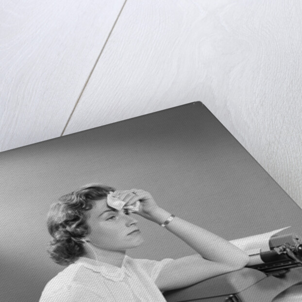 1950s Ailing Secretary Sitting At Desk With Typewriter And Dictation Machine Holding Handkerchief To Forehead by Anonymous