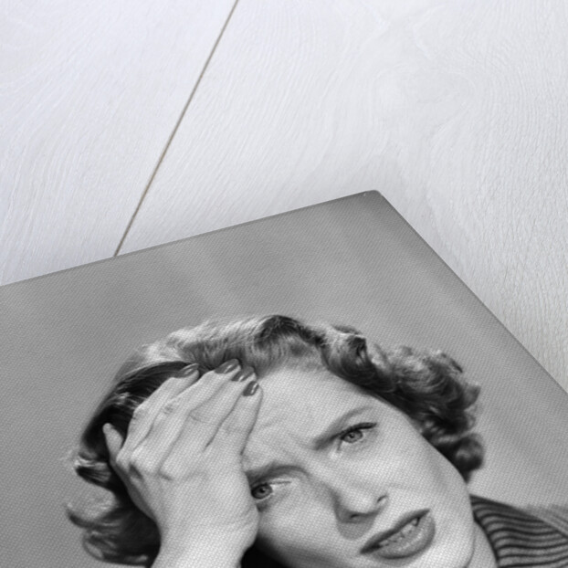 1950s Stressed Woman In Striped Dress Hold Forehead With Hand by Anonymous